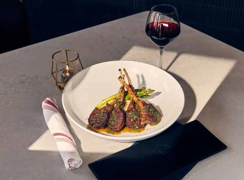 Lamb chops with asparagus and a glass of red wine at Five Corners Ristorante
